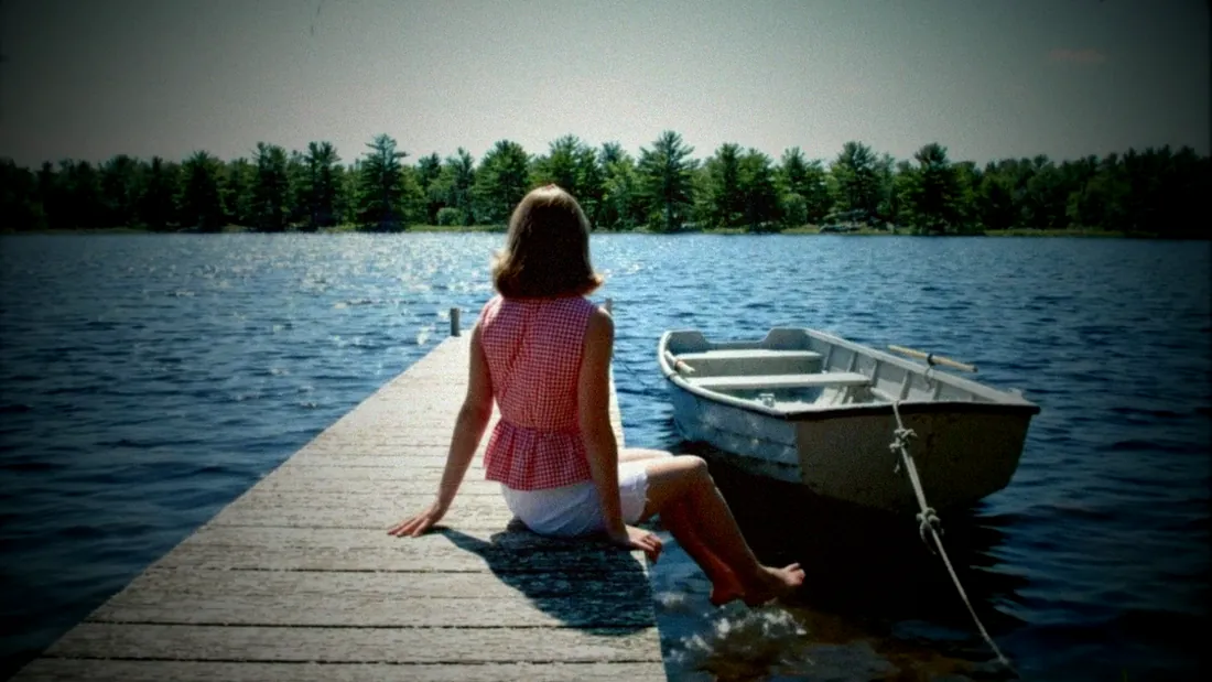 A silent home movie: Peggy at the end of the dock, her back to the camera, waving over her shoulder, 1962.